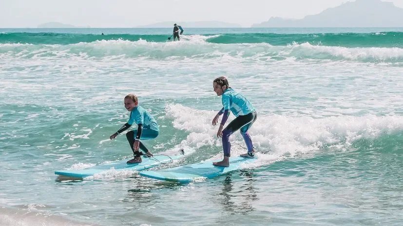 Two kids sharing a wave at an after school surf session