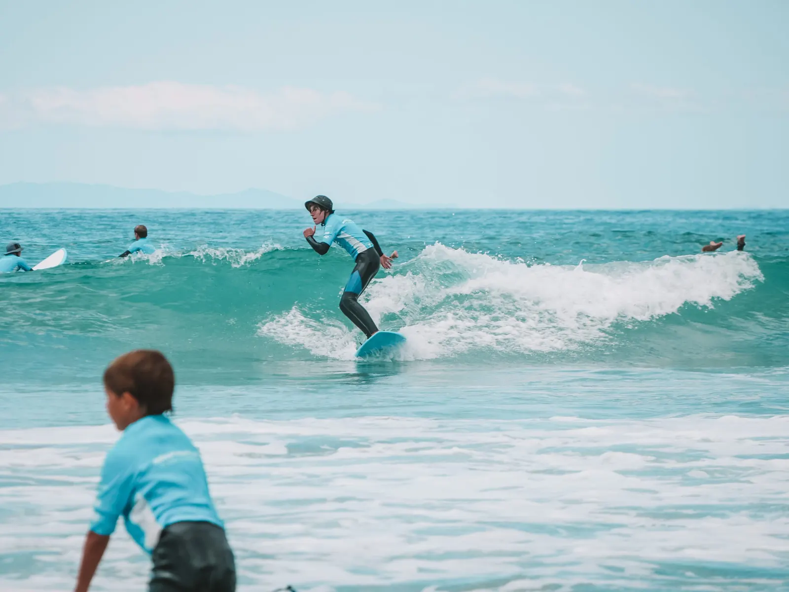 After school surfers riding small waves at Orewa