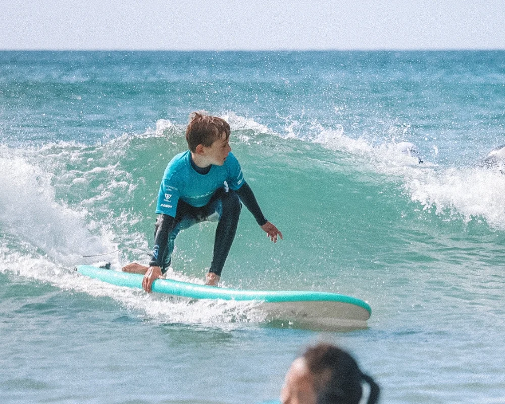 Young surfer crouched into a wave at an after school session