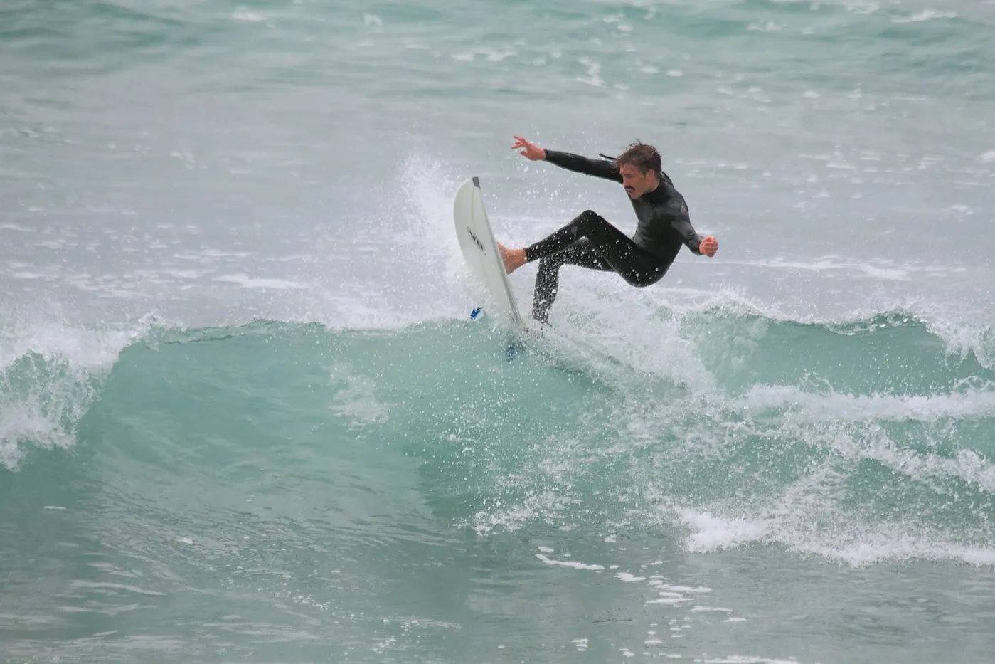 Surfer walking the bank at Mangawhai Heads