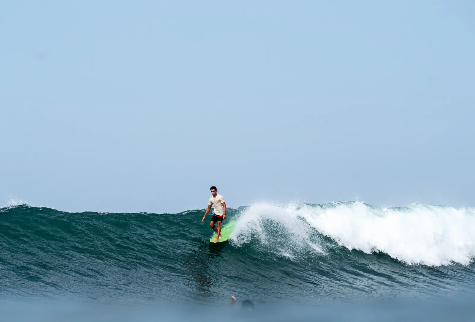 Surfer on a clean wall at a Northland camp beach
