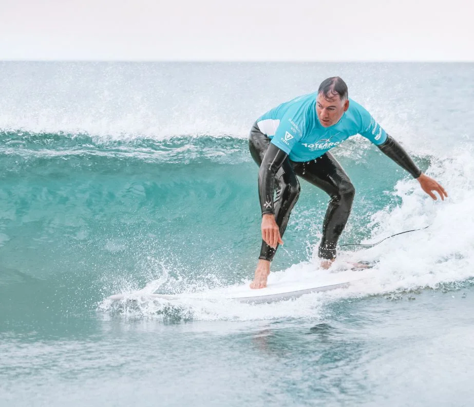 Team member riding a wave on a corporate surf day