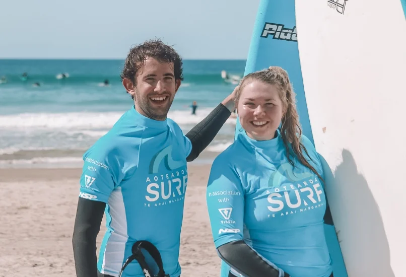 Couple grinning with their boards after a private lesson