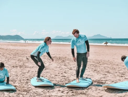 Couple practising pop ups together at their beach lesson