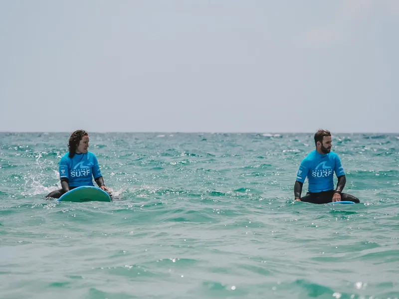 Couple sitting on their boards together out the back
