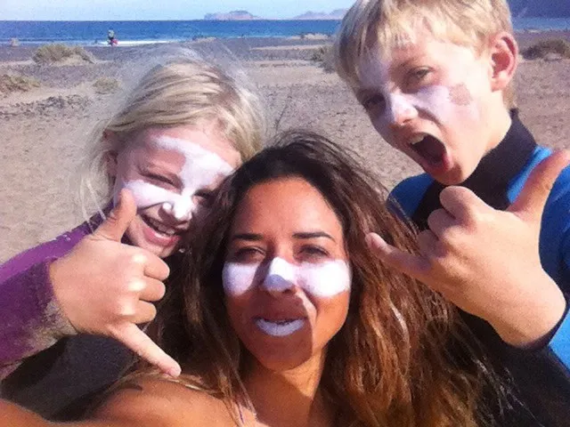 Zinc faced family grinning together at the beach