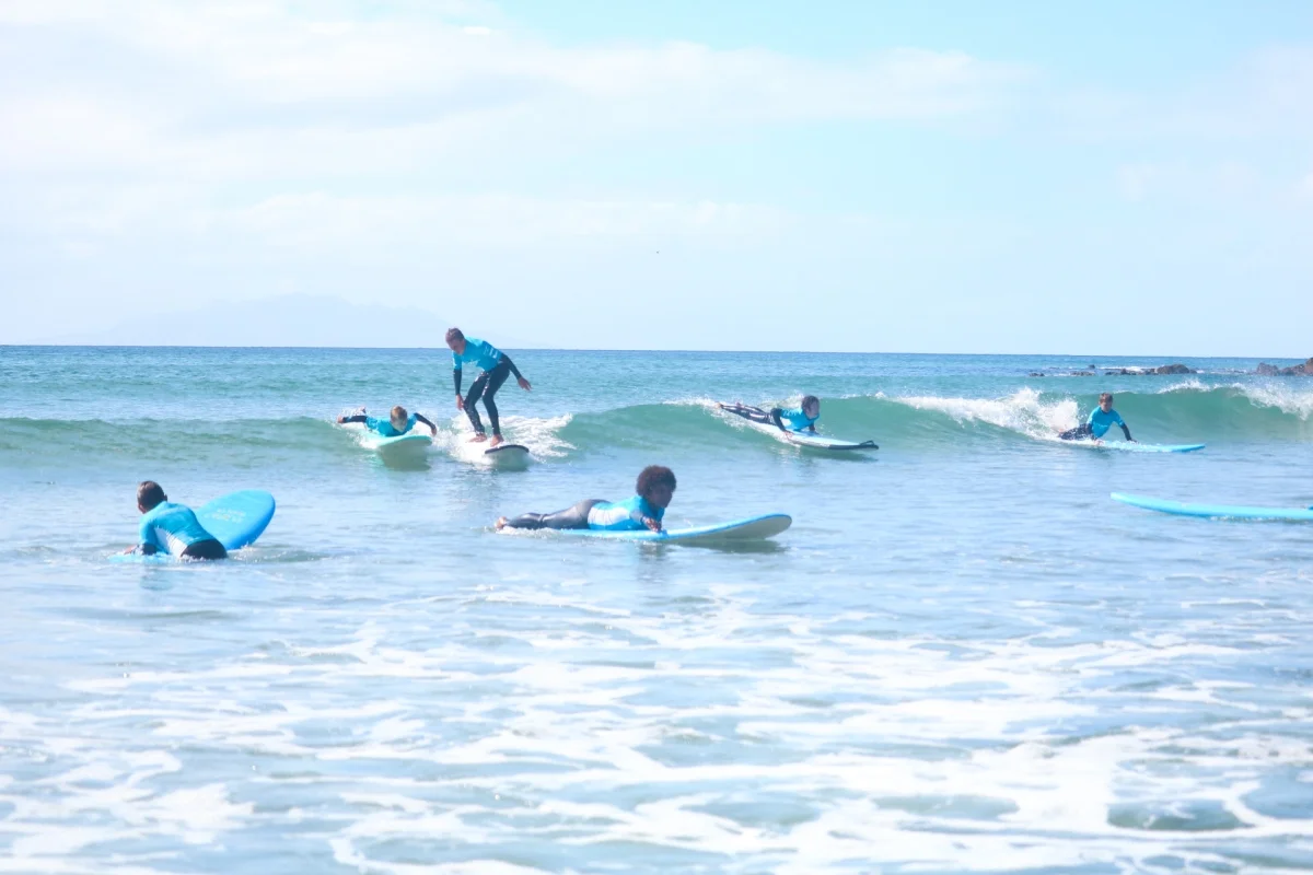 Summer program group session in the waves at Orewa beach