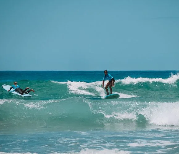 Girl riding a clean summer wave at Te Arai