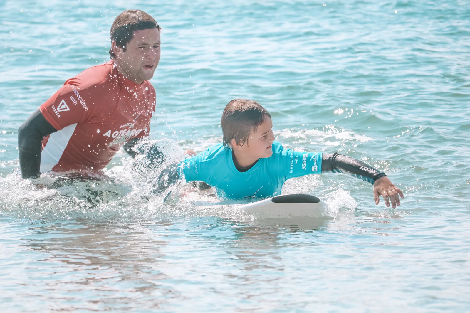 Instructor coaching a young surfer one on one
