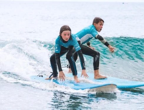Two kids riding a holiday program wave together